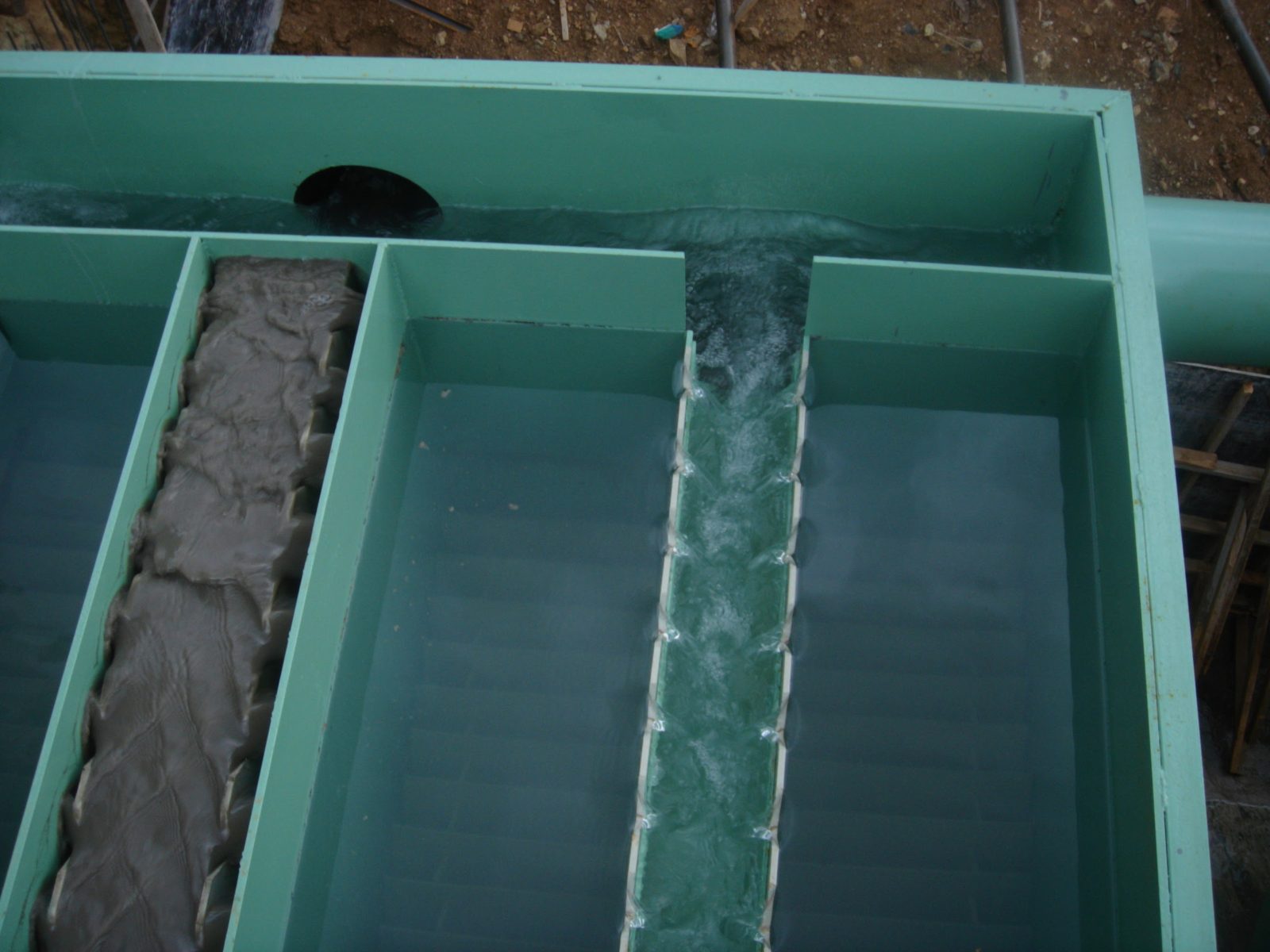 Weir channels of the settling unit at the Adana chrome mine — clear water weirs alongside the dense mineral stream