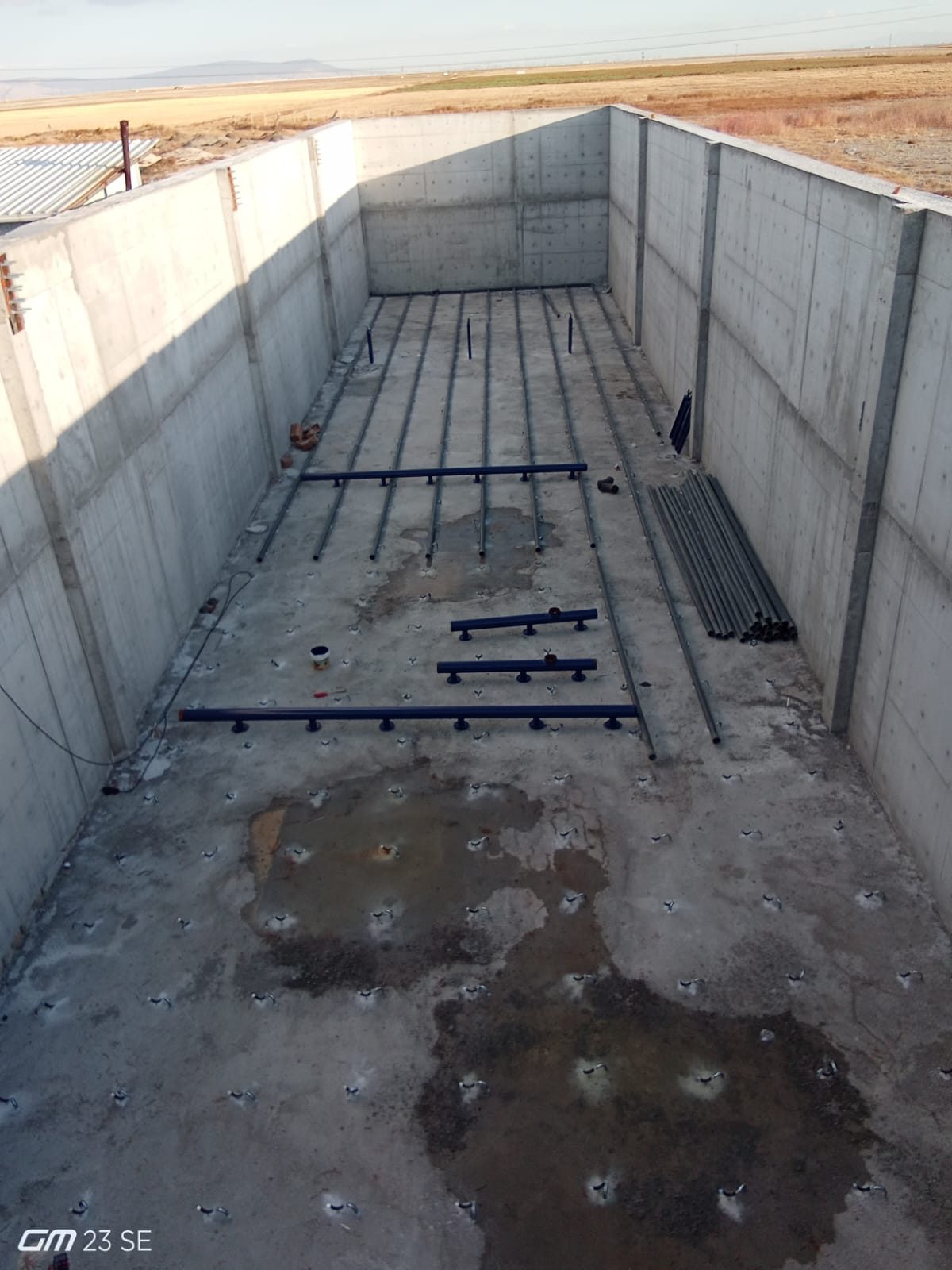 Konsüt treatment plant under construction — pipework being installed on the floor of the reinforced concrete basin, site photo