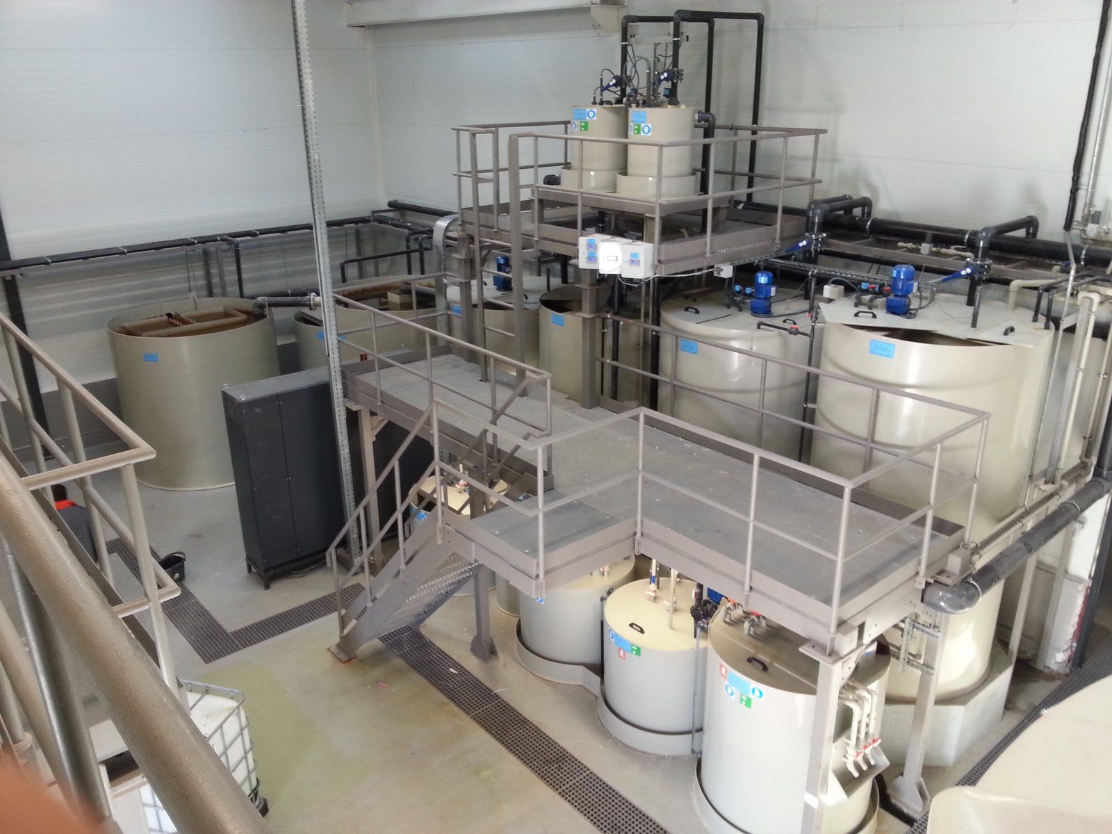 AXOR Industry chemical treatment plant — PP reaction tanks, mixers, dosing units and steel service platform, seen from above