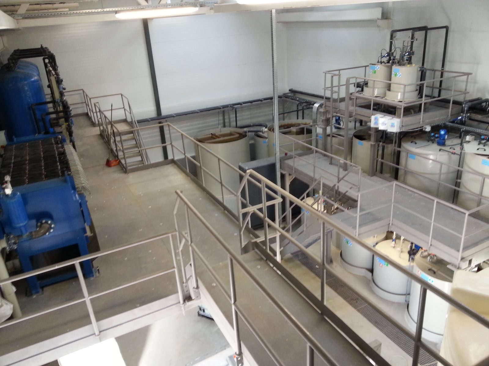 View from the service platform — filter press and pressure filters on the left, PP reaction tanks and dosing deck on the right